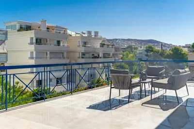 a balcony with chairs and a view of a building at Voula Panoramic Terraces - Greecing in Athens