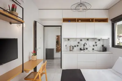 a kitchen and living room with white cabinets at Glyfada Panoramic Penthouse in Athens