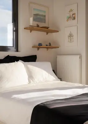a bedroom with a bed with white sheets and a window at Glyfada Panoramic Penthouse in Athens