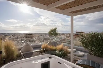a bath tub on a balcony with a view of a city at Glyfada Panoramic Penthouse in Athens