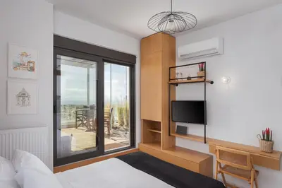 a bedroom with a bed and a view of a balcony at Glyfada Panoramic Penthouse in Athens