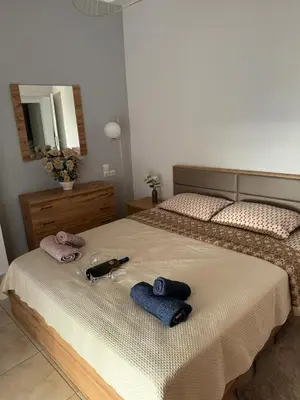 a bedroom with a bed with two towels and a mirror at Sunshine Bliss Apartment in Athens