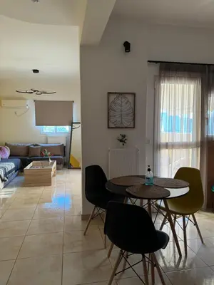 a living room with a table and chairs and a couch at Sunshine Bliss Apartment in Athens
