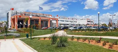 a building with cars parked in a parking lot at Sunshine Bliss Apartment in Athens