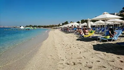 a group of people sitting on a beach with umbrellas at Sunshine Bliss Apartment in Athens