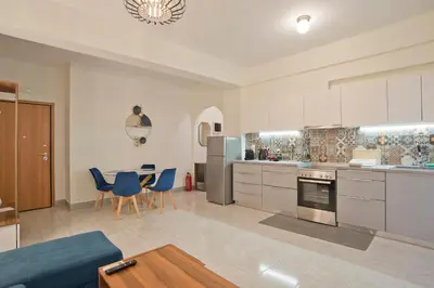 a large kitchen with blue chairs and a table at Milena Comfy Piraeus Reno Apt AC & Full Kitchen in Piraeus