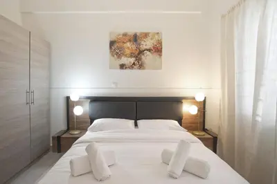 a bedroom with a white bed with two white pillows at Milena Comfy Piraeus Reno Apt AC & Full Kitchen in Piraeus