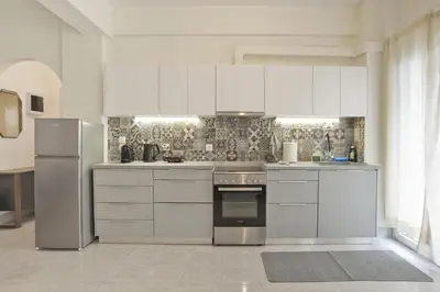 a kitchen with white cabinets and stainless steel appliances at Milena Comfy Piraeus Reno Apt AC & Full Kitchen in Piraeus