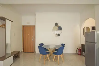 a kitchen and dining room with a table and blue chairs at Milena Comfy Piraeus Reno Apt AC & Full Kitchen in Piraeus