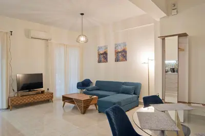 a living room with a blue couch and a tv at Milena Comfy Piraeus Reno Apt AC & Full Kitchen in Piraeus