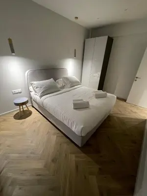 a bedroom with a white bed and a table at Down Town Nea Smyrni in Athens
