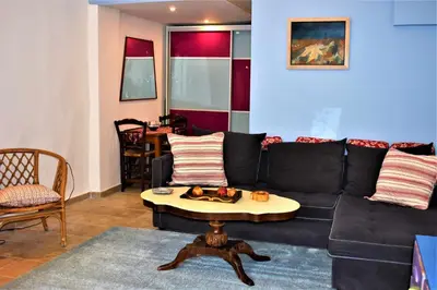 a living room with a black couch and a table at Egaleo Relax Apartment in Athens