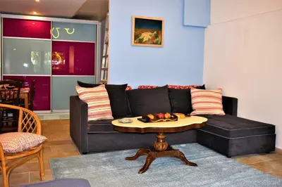 a living room with a black couch and a table at Egaleo Relax Apartment in Athens