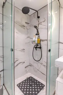 a shower with a glass door in a bathroom at Warm and modern brand new apartment in Piraeus