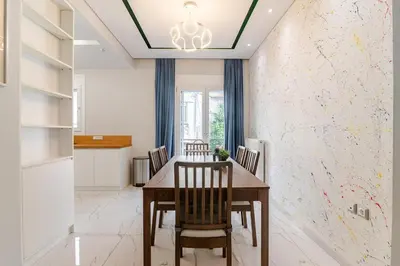 a dining room with a wooden table and chairs at Warm and modern brand new apartment in Piraeus