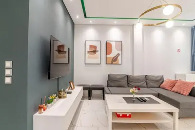 a living room with a couch and a table at Warm and modern brand new apartment in Piraeus