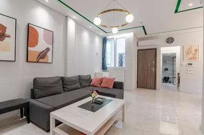 a living room with a couch and a table at Warm and modern brand new apartment in Piraeus