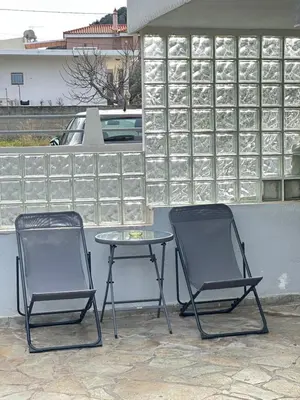 two chairs and a table on a patio at Peaceful Cottage Porto Rafti in Porto Rafti