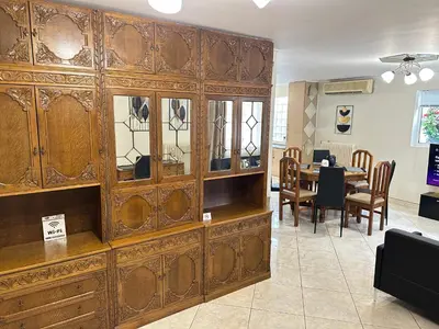 a large wooden cabinet in a room with a table at Peaceful Cottage Porto Rafti in Porto Rafti