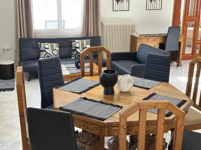 a living room with a wooden table and chairs at Peaceful Cottage Porto Rafti in Porto Rafti