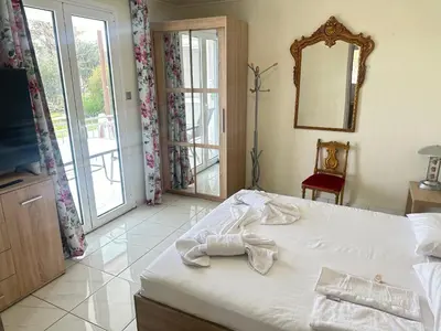 a bedroom with a bed and a mirror and a window at Peaceful Cottage Porto Rafti in Porto Rafti