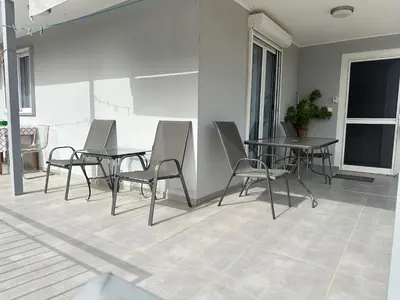a dining room with tables and chairs on a patio at Peaceful Cottage Porto Rafti in Porto Rafti