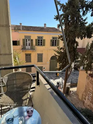 a table and a chair on a balcony with a building at Plaka K15 in Athens