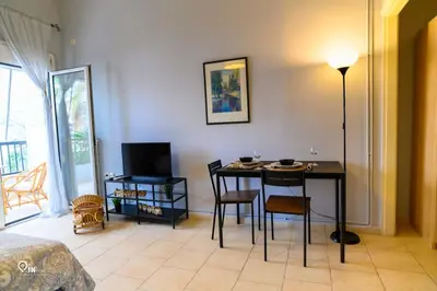 a living room with a table and chairs and a television at Aphrodite - Cozy & Bright Studio in Egaleo-Athens in Athens