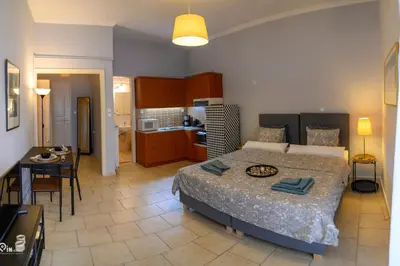 a bedroom with a large bed and a kitchen at Aphrodite - Cozy & Bright Studio in Egaleo-Athens in Athens