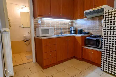 a small kitchen with wooden cabinets and a microwave at Aphrodite - Cozy & Bright Studio in Egaleo-Athens in Athens