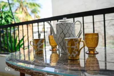 a glass table with a tea pot and four cups at Aphrodite - Cozy & Bright Studio in Egaleo-Athens in Athens