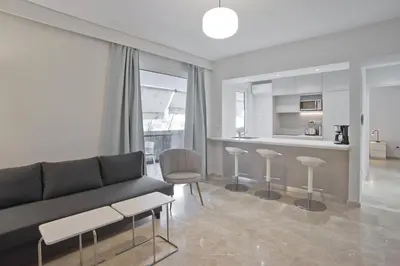 a living room with a couch and chairs and a kitchen at Belle Helene Luxury, Fully Reno, Athenian Riviera in Athens