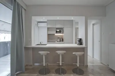 a kitchen with a counter with stools in it at Belle Helene Luxury, Fully Reno, Athenian Riviera in Athens