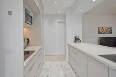 a white kitchen with white cabinets and a sink at Belle Helene Luxury, Fully Reno, Athenian Riviera in Athens