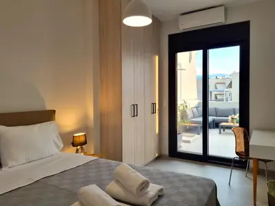 a bedroom with a bed and a sliding glass door at 10 Apartments & Suites Athens in Athens
