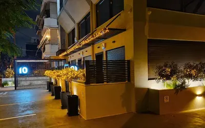 a building with a row of potted plants on a sidewalk at 10 Apartments & Suites Athens in Athens