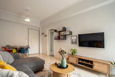 a living room with a couch and a tv at Modern Apartment in Cholargos in Athens