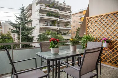 a balcony with a table and chairs and a building at Modern Apartment in Cholargos in Athens