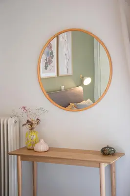 a mirror on a wall above a wooden table at Modern Apartment in Cholargos in Athens