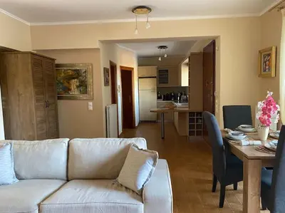 a living room with a white couch and a table at Pool Garden House near the Sea in Vari