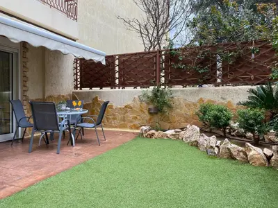 a patio with a table and chairs on the grass at Pool Garden House near the Sea in Vari