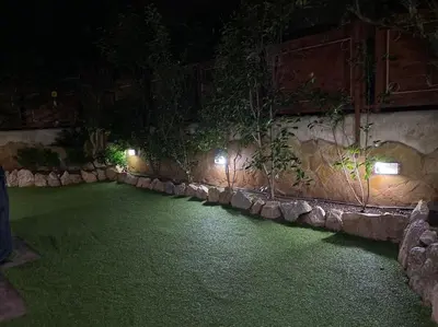 a garden at night with lights on the wall at Pool Garden House near the Sea in Vari