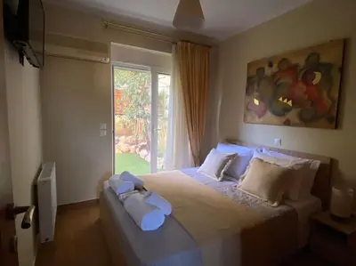 a bedroom with a large bed with towels on it at Pool Garden House near the Sea in Vari