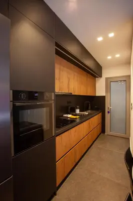 a kitchen with black appliances and wooden cabinets at Carmen's cozy&luxury apartment! in Athens