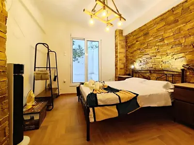 a bedroom with a bed and a brick wall at Dimelli's Home in Athens - Comfort & Style Stay in Athens