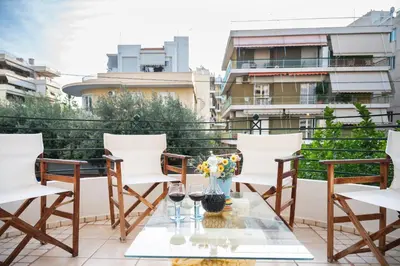 a patio with chairs and a table with glasses of wine at Artistic Villa Luxury in Athens
