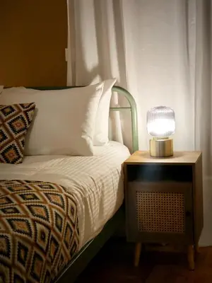 a bed with a table with a lamp on it at Caravin Wanderhome Acropolis, 1 min from Acropolis Museum in Athens
