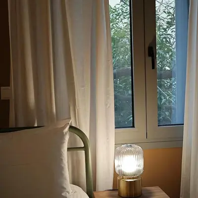 a lamp sitting on a table next to a window at Caravin Wanderhome Acropolis, 1 min from Acropolis Museum in Athens