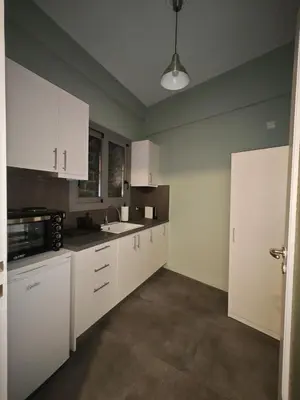a kitchen with white cabinets and a sink at Caravin Wanderhome Acropolis, 1 min from Acropolis Museum in Athens