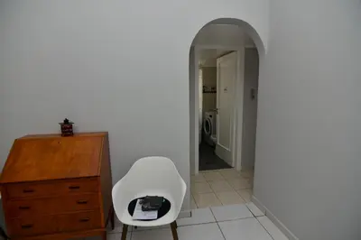 a room with a white chair and a wooden dresser at Athenian Riviera Beach front apartment 2 minutes from Tram stop in Athens
